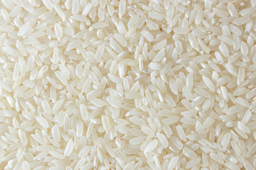 Dry Uncooked White Rice Background - Top View, Flat Lay. Scattered Raw Long Grain Rice. Asian Cuisine and Culture. Healthy Eating Ingredients. Diet Food