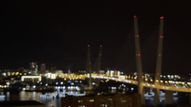 Bokeh blurred night city lights on road with big bridge over bay