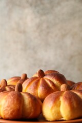 Tasty pumpkin shaped buns on table, closeup