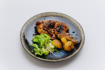Juicy roasted chicken with black pepper, grilled potatoes, and fresh greens, elegantly plated