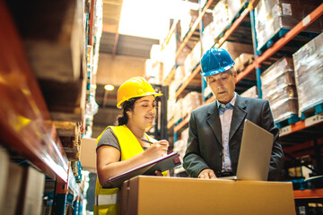 Warehouse worker discussing logistics with manager over a laptop