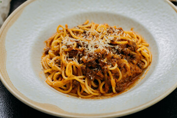 Classic spaghetti Bolognese topped with Parmesan, served in an elegant setting