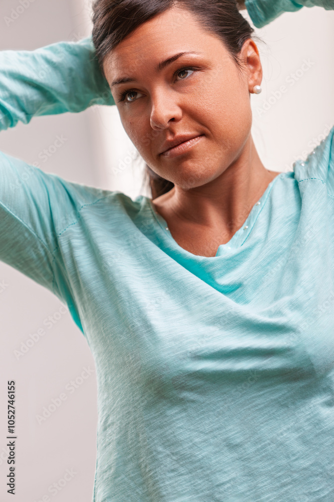 Wall mural Woman adjusting hair while looking away