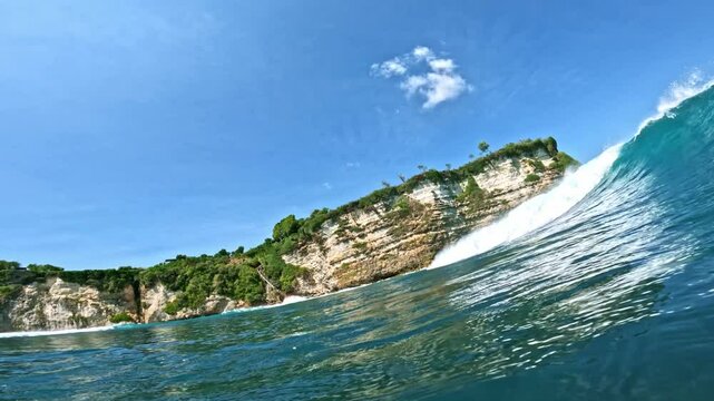 Surfing wave in Bali island. Ocean wave clear water. Uluwatu famous surf destination in Indonesia. Adventure travel. Slow motion.