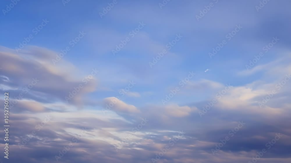 Poster Clouds in shades of white and grey slowly transform as they drift across a vibrant blue sky, creating a mesmerizing display of nature's beauty and atmospheric dynamics