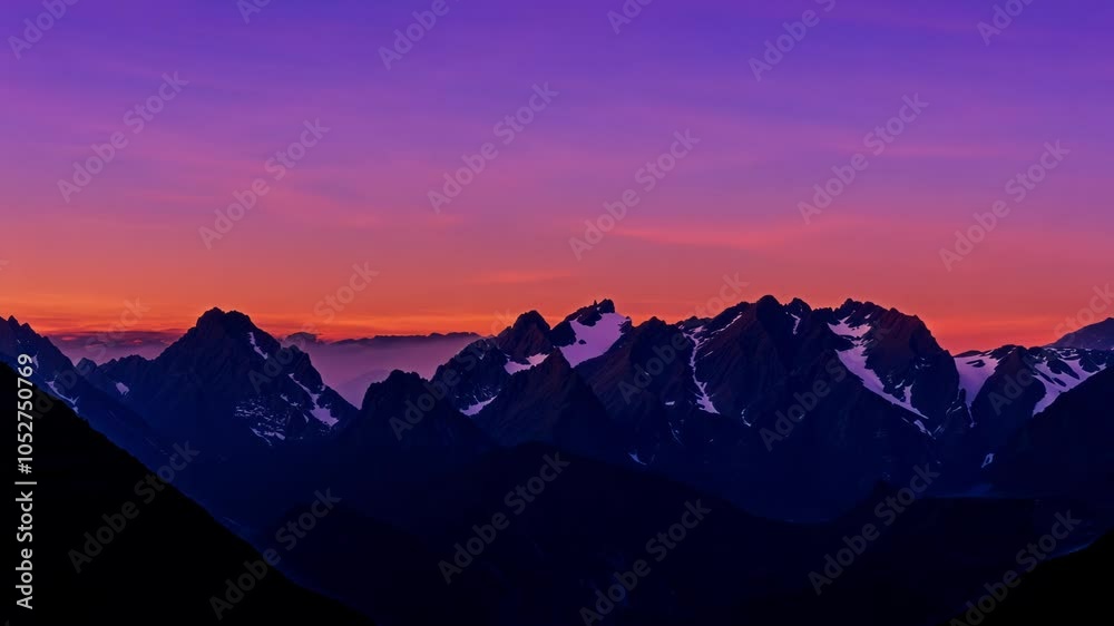 Poster Mountain range is illuminated by the setting sun. The colors of the sky and mountains gradually shift from warm oranges and yellows to cool purples and blues