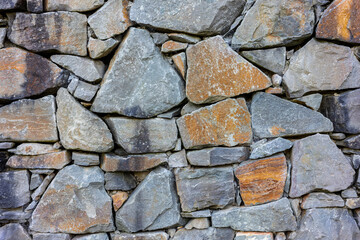 Stone wall texture with irregularly shaped rocks and stones