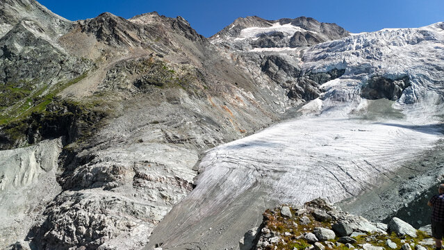 Drone view of the Moiry Glacier in Switzerland, showcasing its rugged, icy surface and surrounding mountain landscape