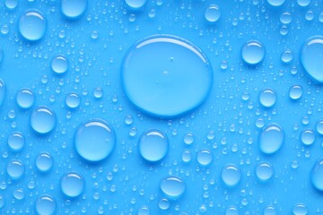 Water drops on blue background, top view