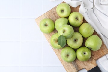Fresh ripe green apples on white tiled table, top view. Space for text