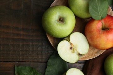 Different ripe apples on wooden table, flat lay. Space for text