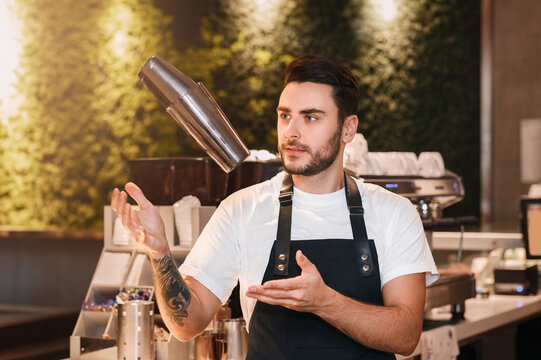 Professional Bartender Barista Using Shaker Making Coffee Cocktail Standing At Bar Counter In Cafeteria.