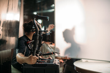 Professional cinema and video camera on the set. Shooting shift, lighting fixtures, shooting equipment and the team. Technique of modern filming and advertising.