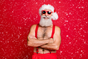 Portrait of his he nice attractive content cheerful cheery funky glad gray-haired muscular macho St Saint Nicholas folded arms wintertime isolated over bright vivid shine red background