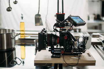 Fototapeta premium Professional cinema and video camera on the set. Shooting shift, lighting fixtures, shooting equipment and the team. Technique of modern filming and advertising.