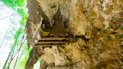 Wooden Coffin with Skull Inside, Resting on a Cliff Face. Toraja cliff burial