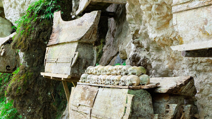 Wooden Coffins and Human Skulls Resting on a Cliffside in the Indonesian Jungle. Toraja Burial Cliff