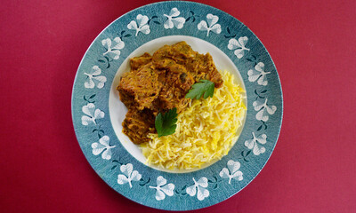 Chicken Mughlai with saffron rice on a plate.