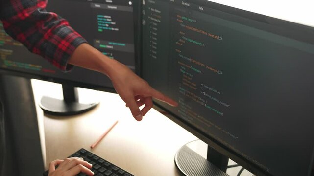 Slow motion back end or software developer manager supervising his team on new application program development on debugging and solving complex code algorithms on monitor. Burgeoning