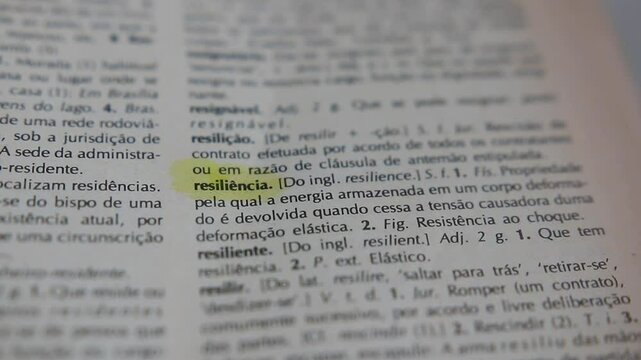 A man marks the word inattentive definition in portuguese on a printed page with a marker pen