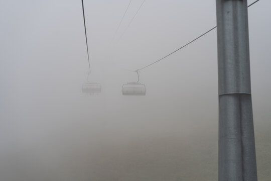Cable cars vanishing in thick fog in Stoos, Switzerland