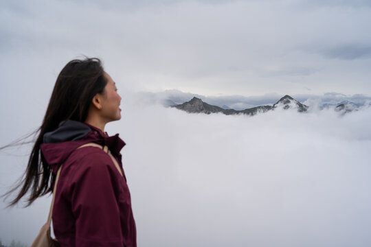 Woman gazing at mountain peaks through clouds in Stoos, Switzerland