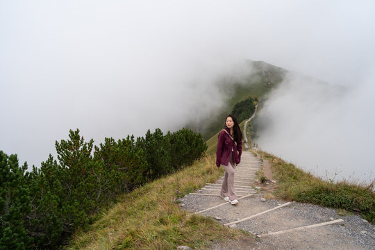 Young asian woman hiking in foggy Stoos, Switzerland