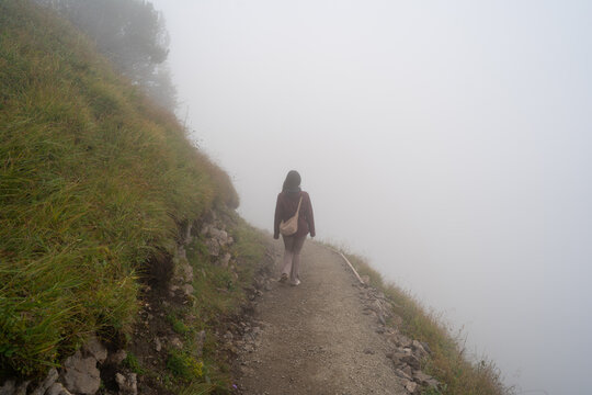 Misty mountain trail with lone hiker in Stoos, Switzerland