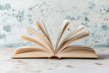 Open book on table, sunlight casts shadows on pages. A pair of reading glasses lies beside it. Cozy...