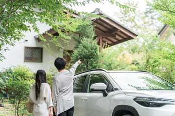 旅行でペンション・コテージに車でやってきたカップル・夫婦
