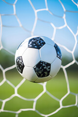 A soccer ball hits the net during a sunny afternoon match in the park