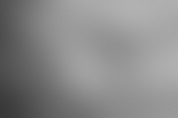 Obraz premium A blurry gray background with a white object in the foreground. Noisy backdrop with grain