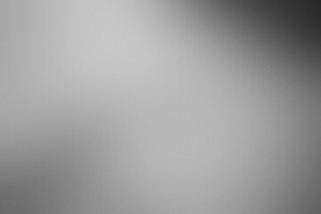 A blurry gray background with a white object in the foreground. Noisy backdrop with grain