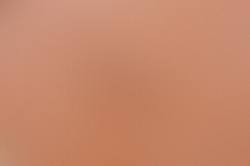 A tan background with a blurry image of a person. Noisy backdrop with grain