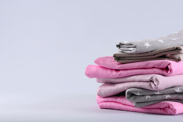 Stack of clean bed sheets on white background. Space for text