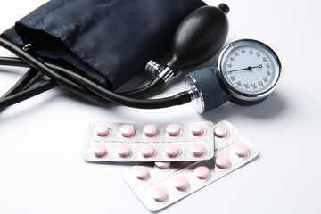 Blood pressure measuring device and pills in blisters on light background