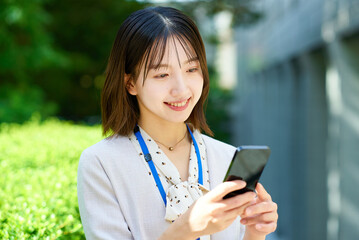 スマートフォンを手にする若いビジネスウーマン