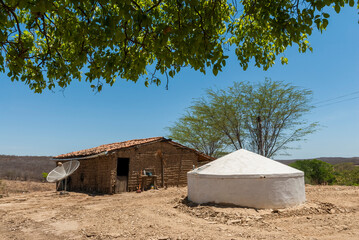 Wattle and daub house made with clay and wooden sticks, with a water cistern to withstand drought...