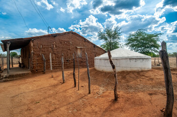 Wattle and daub house made with clay and wooden sticks, with a water cistern to withstand drought...