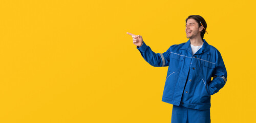 Construction Workers Hire Concept. Portrait Of Young Civil Engineer In Uniform Pointing Aside At Copy Space On Light Background