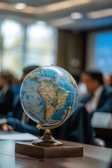 A close-up of a vintage globe on a polished desk highlights South America and Africa.
