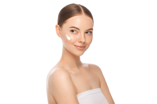 Young woman looking away after applying face cream to cheeks as part of morning routine