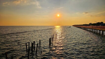 Sunset view at sea shore with red bridge walk way landscape, Thailand.