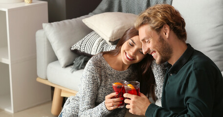 Couple drinking delicious mulled wine at home