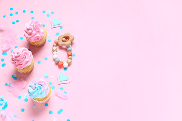 Delicious cupcakes with kid bracelet and decor on pink background. Gender reveal party concept
