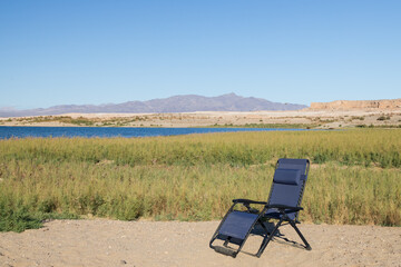 Blue lounge chair in the desert with Lake Mead National Recreational Area in background