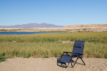 Blue lounge chair in the desert with Lake Mead National Recreational Area in background