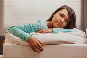 Naklejka premium Young woman relaxing on sofa at home feeling in control of life