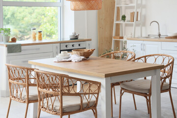 Interior of light kitchen with dining table and counters