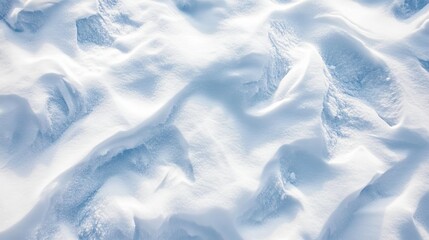 Obraz premium 2410 7.A top-down view of freshly fallen snow covering the ground, with soft, intricate textures forming across the surface. The snow creates gentle waves and smooth mounds, with delicate shadows